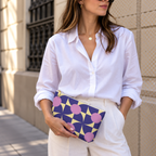 Woman in a white shirt holding the purple pink geometric makeup bag as a clutch