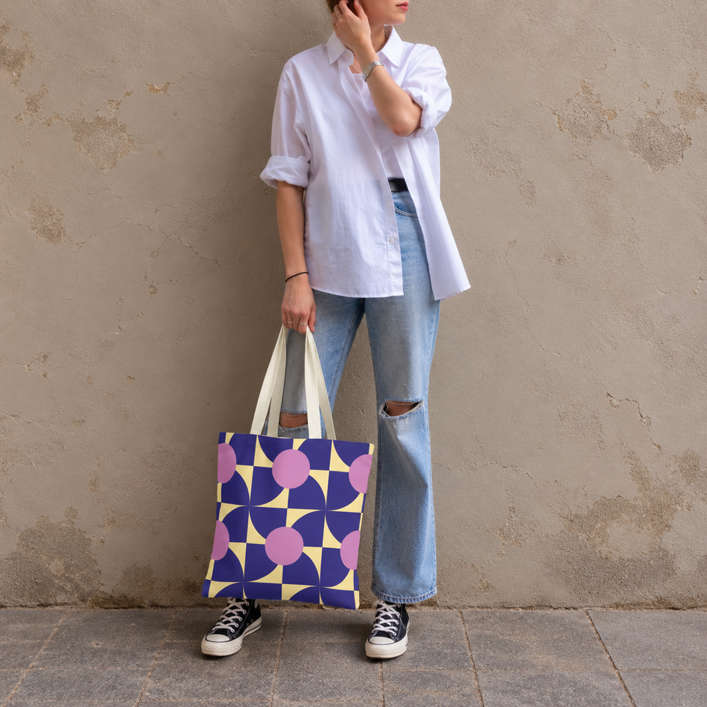 Woman standing in jeans and a white shirt with the purple pink geometric tote bag