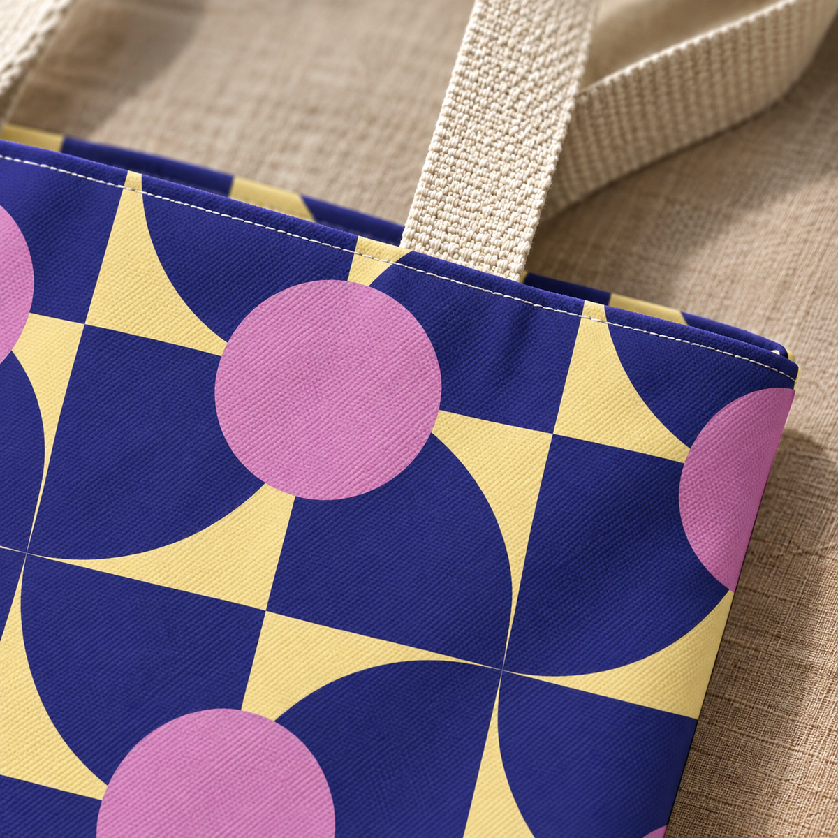 Close-up of the purple pink geometric print and handle on the tote bag