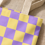 Close-up of the purple yellow checkered print and handle on the tote bag
