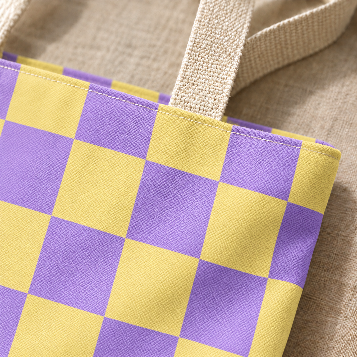 Close-up of the purple yellow checkered print and handle on the tote bag