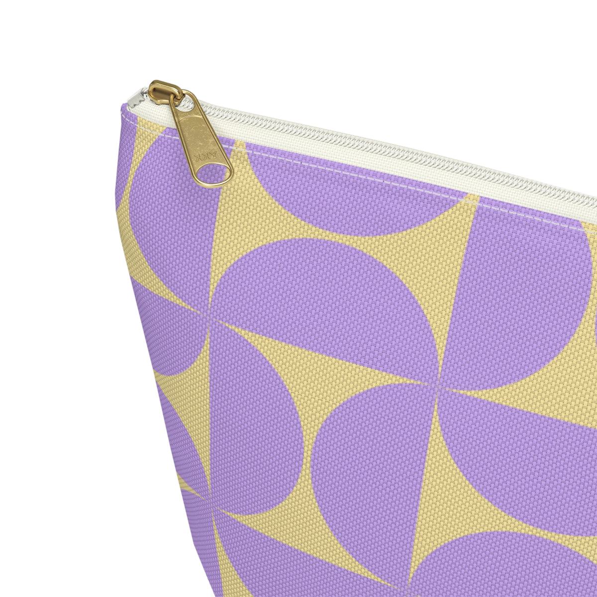 Close-up of the gold zipper pull on the purple yellow geometric makeup bag
