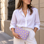 Woman in a white shirt holding the purple yellow geometric makeup bag as a clutch