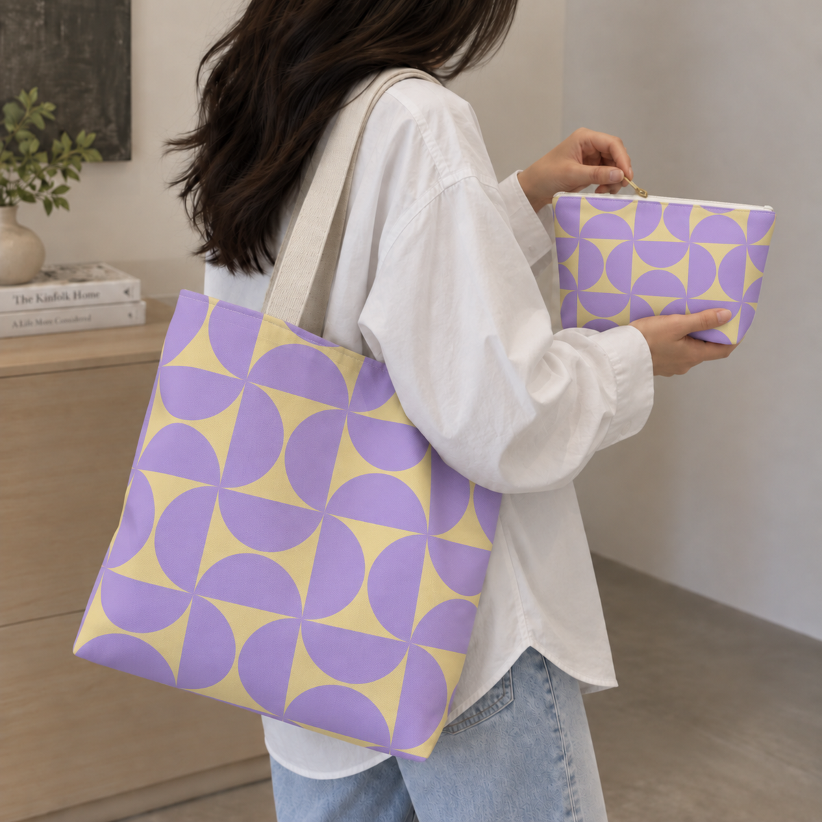 Woman holding the purple yellow geometric tote bag and matching makeup bag