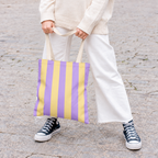 Model in white trousers carrying the Purple Yellow Striped tote bag
