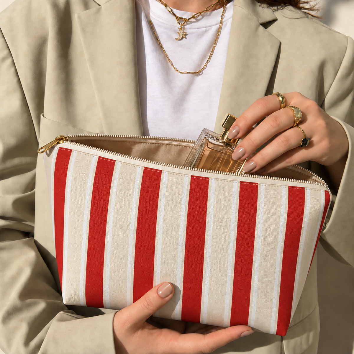 Hands holding the open red cream striped makeup bag