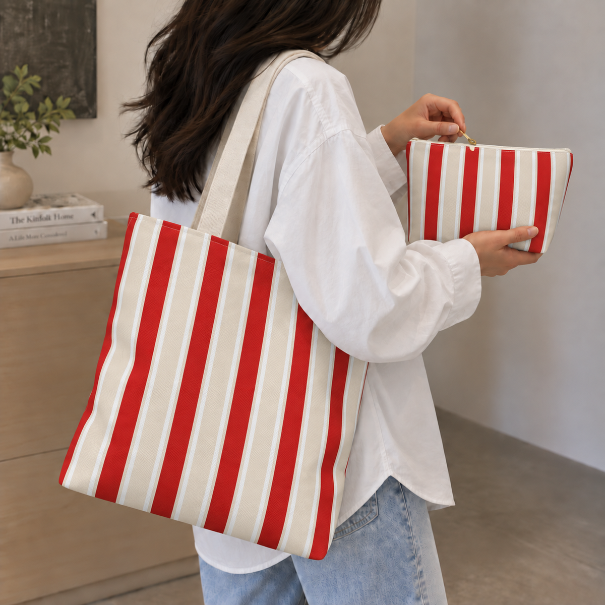 Woman wearing the red cream striped tote bag with the matching makeup bag in her hand