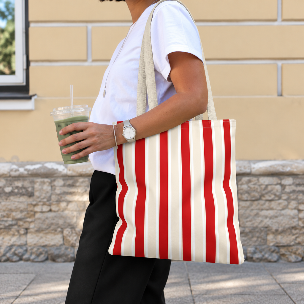 Woman carrying the red cream striped tote bag on her shoulder on the street