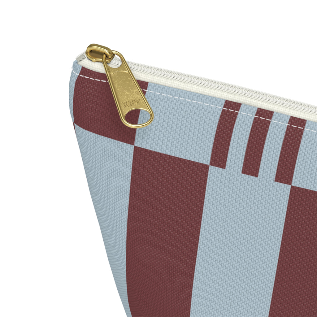 Close-up of the gold zipper pull on the sky blue burgundy block striped makeup bag