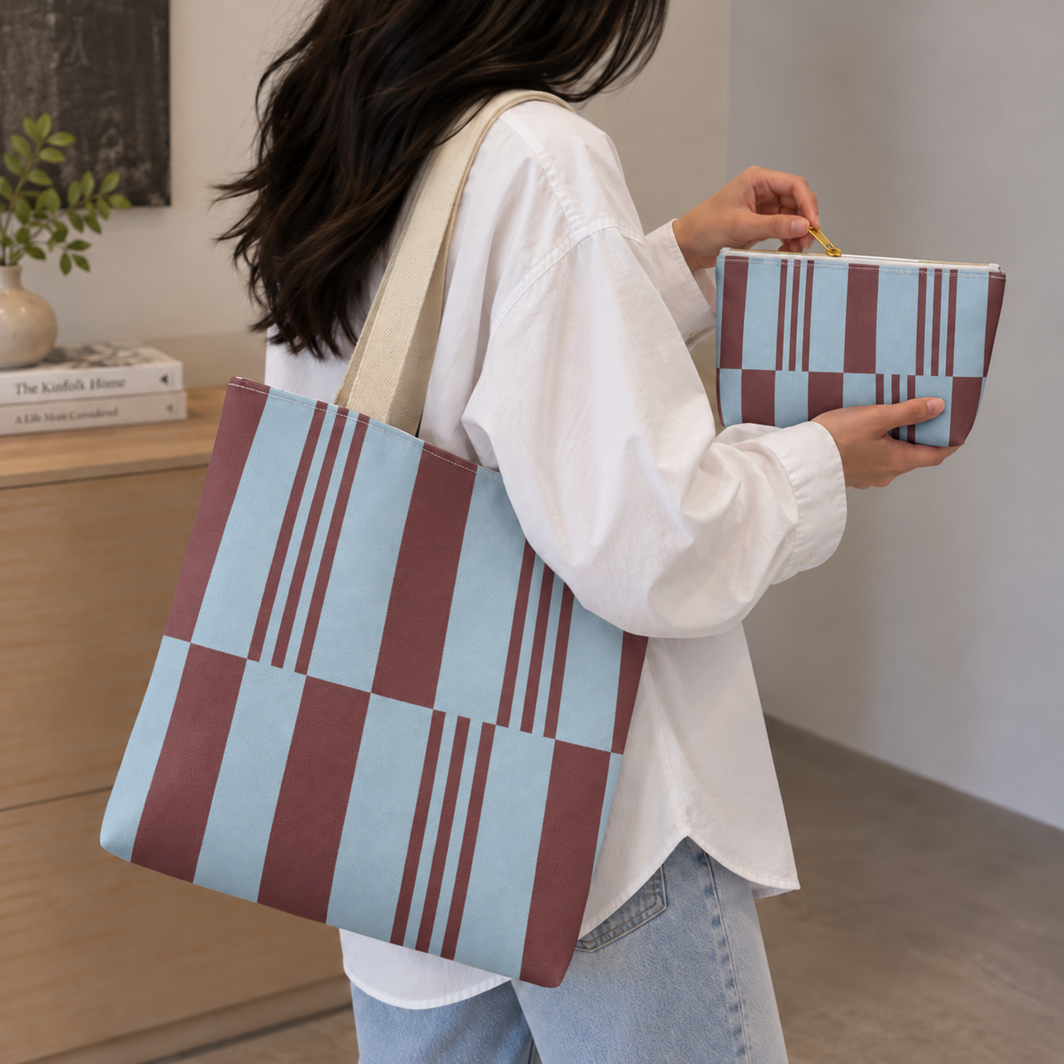 Woman in a white shirt carrying the sky blue burgundy block striped tote bag with the matching makeup bag