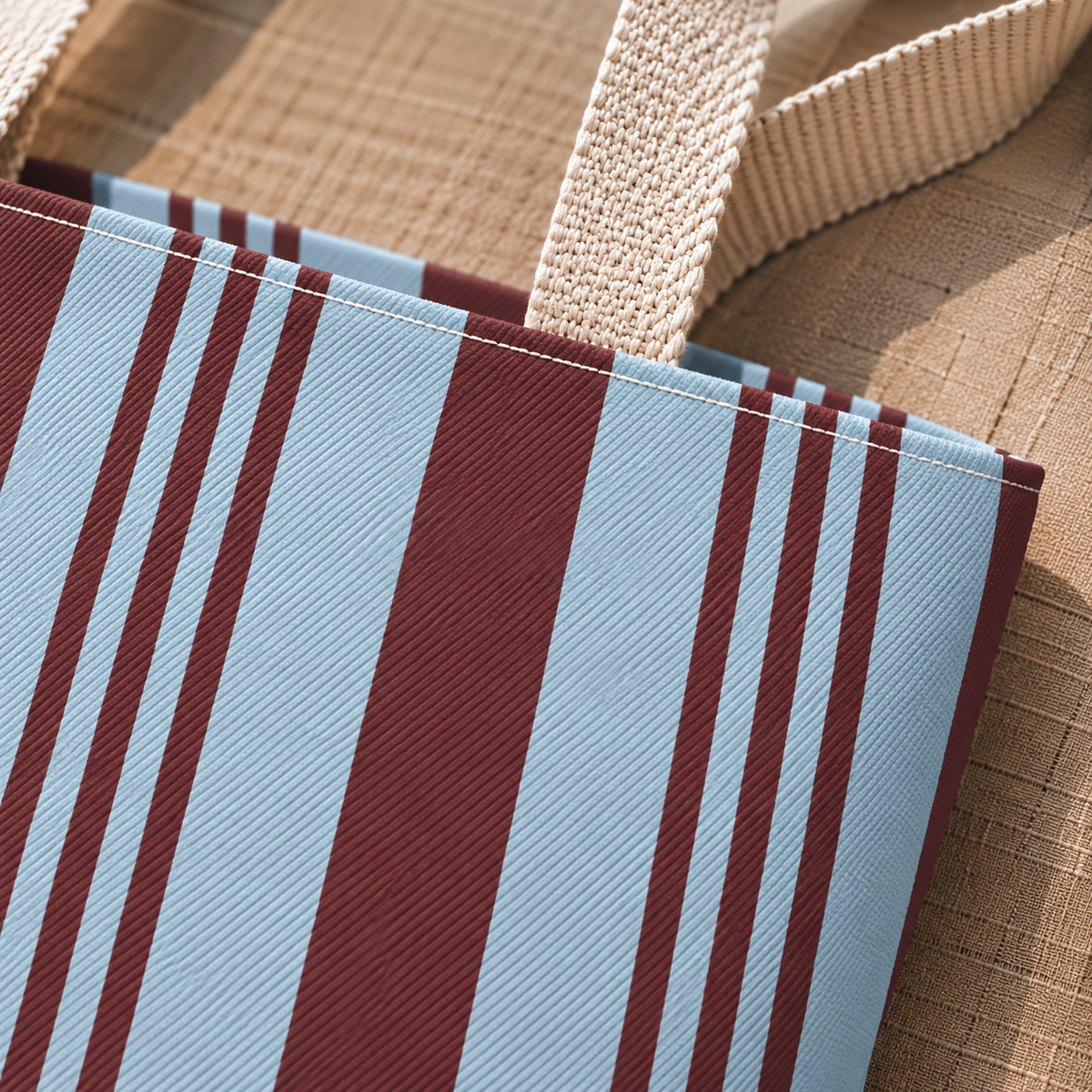 Close-up of the sky blue and burgundy stripes with beige handle on the tote bag