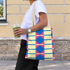 Side view of a model carrying the geometric tote bag in yellow, pink and blue