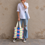 Model in jeans standing with the yellow pink blue geometric tote bag